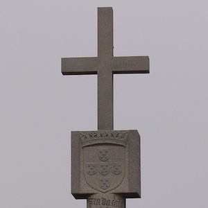 A stone monument with a cross on top