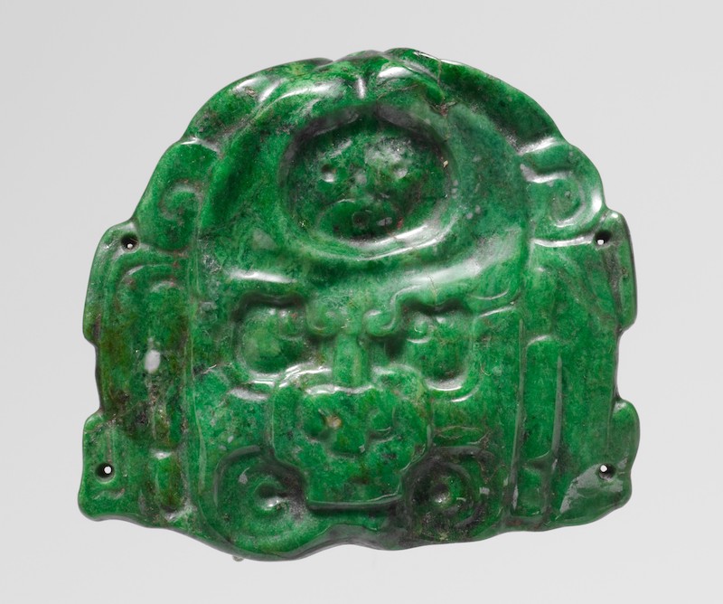 Small jade ornament that portrays a face.