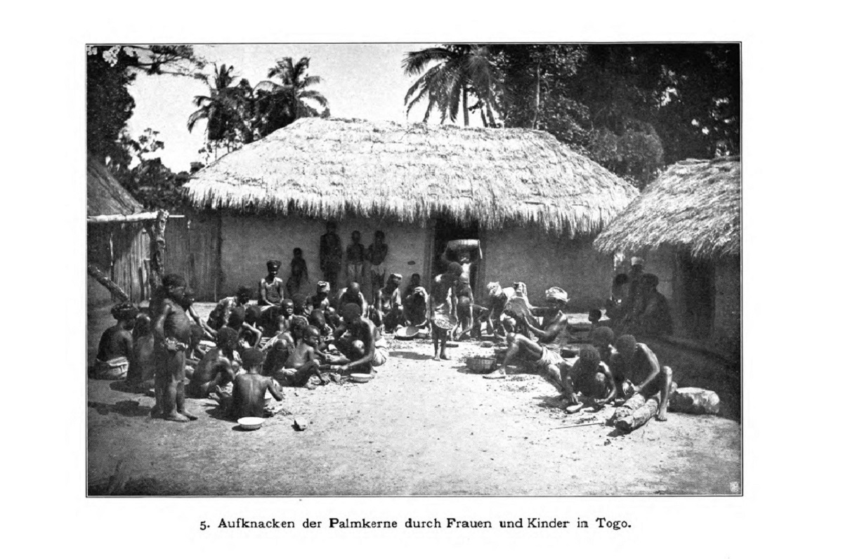 Picture of families in Togo cracking oil palm kernels 