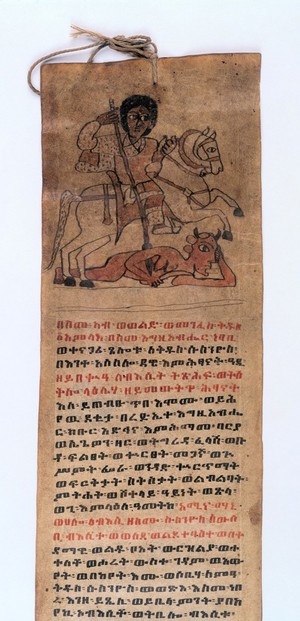 A brown, rectangular paper used as a healing scroll.  there is a drawing of a saint riding a horse and using a spear to destroy a demon. Underneath there is a written prayer in red and black ink in the Ge'ez script. There is a hole with a rope through the top of the scroll.