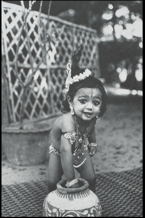 thumbnail of Krishna's mischievous pranks such as stealing sweet butter are reenacted by this child on Krishna's birthday