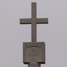 A stone monument with a cross on top