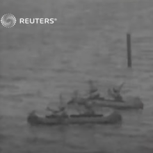 Video still showing Scouts paddling canoes 