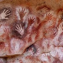 Cave painting with red paint outlining hands. 