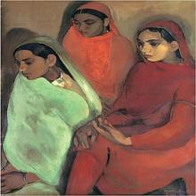 Three girls sitting with gazes cast downward. Each wearing a different-colored sari. The girl on the left is wearing light green, the girl in the middle is in orange, and the girl on the right is in red.